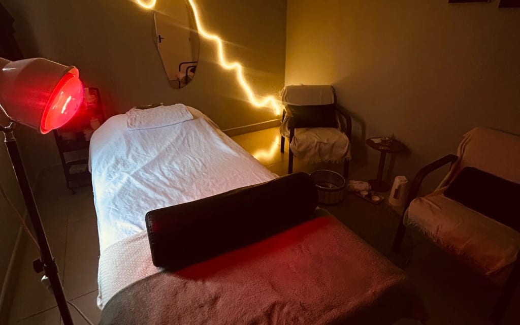 Sala de atendimento com maca e iluminação aconchegante